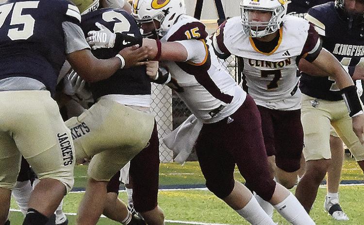 Clinton’s No. 15 Gavin Evans pushes against the Kingfisher ball carrier as he tries to stop him with No. 7 Easten Powell coming to help during the Red Tornadoes’ road game Friday against the Yellowjackets. CDN | John Kinsey