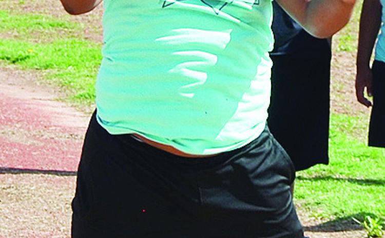 Clinton’s Jamarley Littleton leaps as far as he can in the long jump event as part of the Little Olympics to end the school year. CDN |Sam Goodwyn