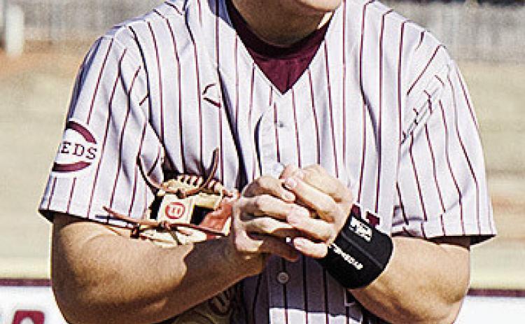Clinton’s Easten Powell rubs the ball as he prepares to pitch during the Reds’ spring home game against El Reno. CDN | Sam Goodwyn