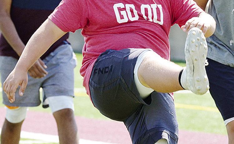 Clinton’s Isaiah Dustman performs high kicks prior to football practice in the Tornado Bowl. CDN | Sam Goodwyn