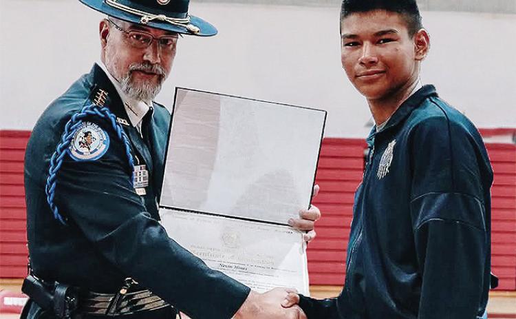 Deputy Director of the Bureau of Indian Affairs Glen Melville, left, presents soon to be Clinton High School freshman Nevin Hines his certificate for graduating through the Bureau of Indian Affairs’ Youth Police Academy program at the Riverside Indian S