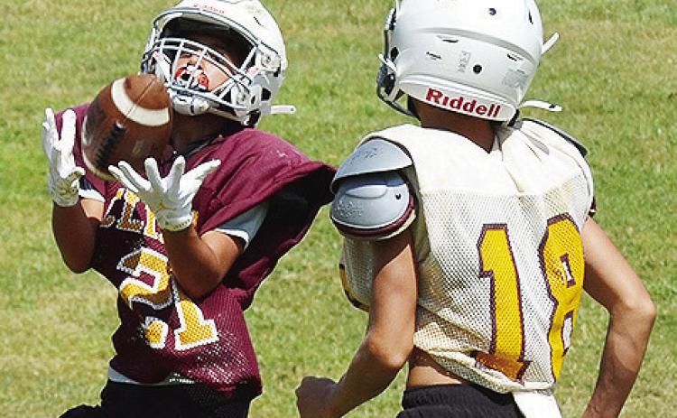 Clinton’s BentLee Potter, left, catches the ball right in front of Chance Roper during practice at the Middle School. CDN | Sam Goodwyn