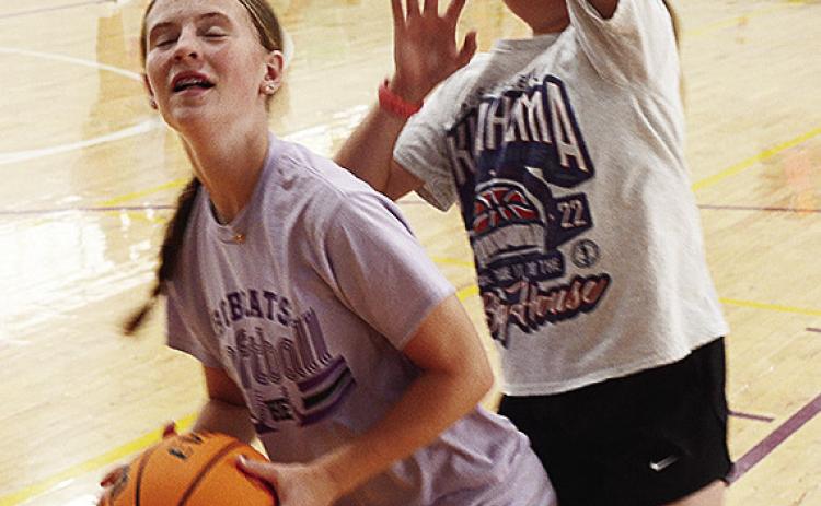 Rennie Kaney, left, tries to drive to the basket while Emmylou Winters guards her during a basketball camp in the practice gym. CDN | Sam Goodwyn