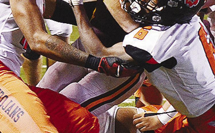 Clinton’s Benton Bridgeman fights through a tackle during the Red Tornadoes’