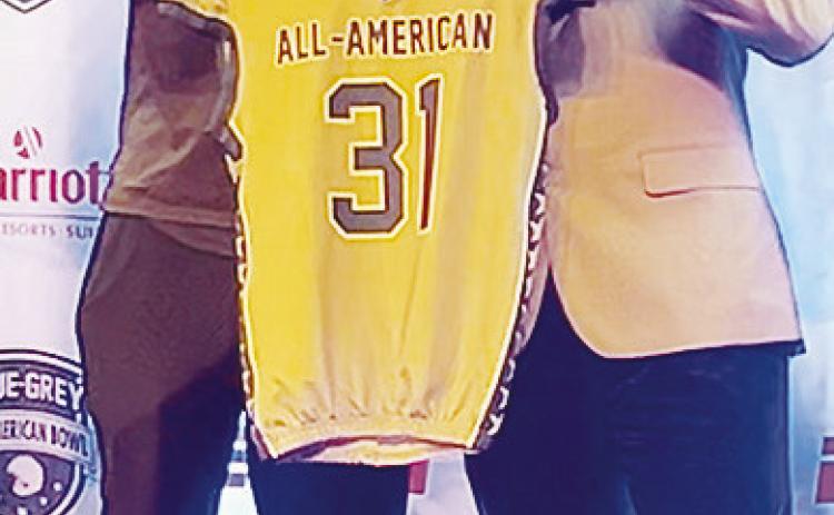 Clinton’s Zaedon Collins, right, accepts his game jersey from NFL vet Victor Butler, who also served as Collins’ defensive coordinator, prior to the All-Star Game. CDN | Courtesy photo