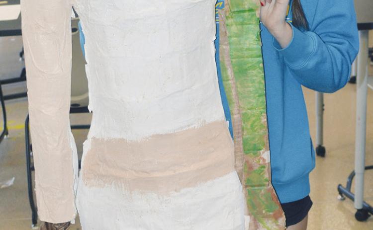 Opal Smith shows the sculpture of her friend, Chanel East, whom is unable to be in the art class with her this year at Clinton Middle School. CDN | Christian Jacobsen