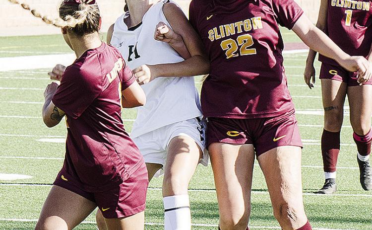Clinton’s Aaliyah Lopez, right, heads the ball to her teammate Sammy Meraz, left, while fighting off the Harding Charter defender during the Lady Reds’ blowout win Monday at home over the Lady Eagles. CDN | Sam Goodwyn