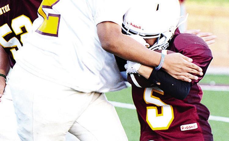 No. 72 Chase Spottedwolf tries to take down Adrien Lopez as he carries the ball during their Clinton Next game. CDN |Sam Goodwyn