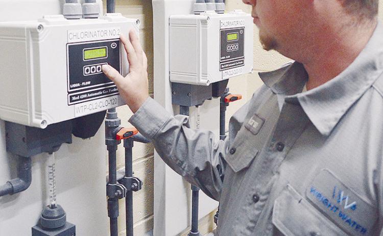 Aaron Ruben adjusts the level of chlorine gas with an automatic gas feeder in the new Chemical Feed Building at the Clinton Lake Water Treatment Plant. CDN | Micah Ashcraft