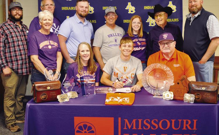 Nate Hickey, seated at center, signs his National Letter of Intent to compete in shooting sports for Missouri Valley College. Seated with him, from left, are his mother Erin Hickey, MVC coach Shawn Dulohery; standing, Mitchell Hunter, his grandmother Nanc