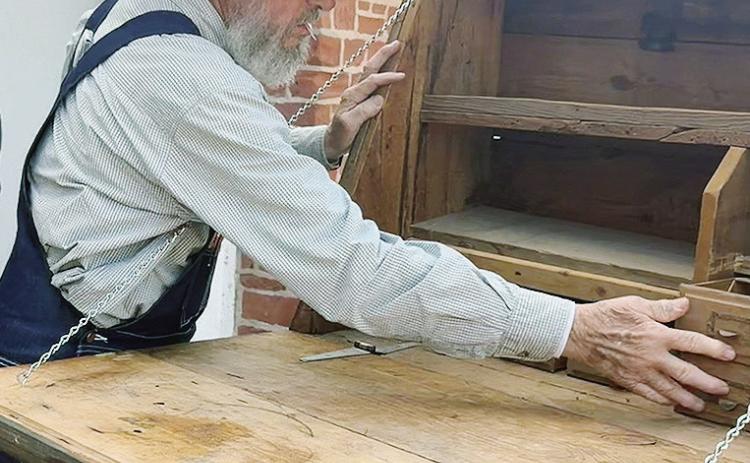 Tom Ward of PropsWest examines the peddler’s cart, which is one of approximately 40 props the company is supplying for the production of “Oklahoma!” this fall. CDN | Shiann Dawson