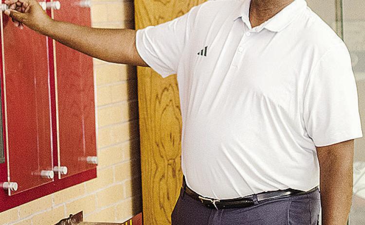 Clinton’s Athletics Director Eugene Jefferson looks over the Hall of Fame display in the Tornado Dome Monday, as he mentally designs the addition with the new class being inducted Saturday at the Frisco Center. CDN | Sam Goodwyn
