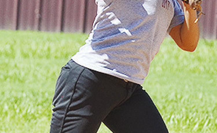 Senior Audrina Trout hurls the ball toward first during practice Tuesday at the softball fields. CDN | Sam Goodwyn