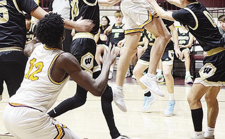 Clinton’s Ayden Crumley flies through the air as he passes the ball to No. 12 Atticus Thompson through a horde of defenders during the Reds’ home game Tuesday against Woodward. CDN | Sam Goodwyn