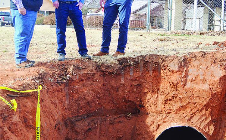 From left, Dist. 1 Commissioner Wade Anders, Gary Brickley, and Clinton Public Works Director Gene McCullough take note of the state of a damaged drainage pipe Monday afternoon in McLain Rogers Park, just outside of the Clinton Public Pool. CDN | Micah As