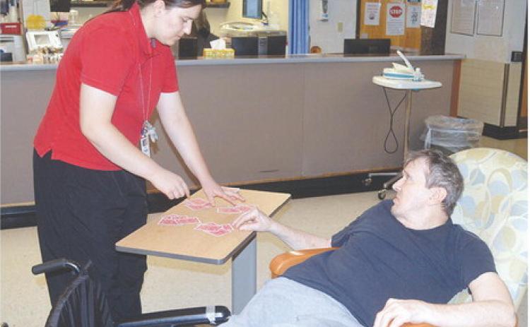 Amelia Hardaway, left, has Frankie Gill select a pile of cards during a magic trick at the Oklahoma Veterans Center, Clinton Branch. CDN | Christian Jacobsen