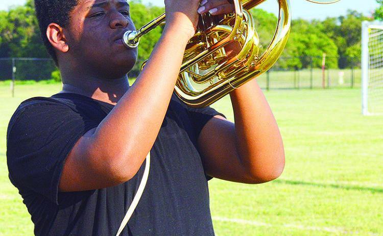 Kristian Bennett holds at attention during an after-school marching band rehearsal for the Pride of Clinton Monday evening. CDN | Micah Ashcraft