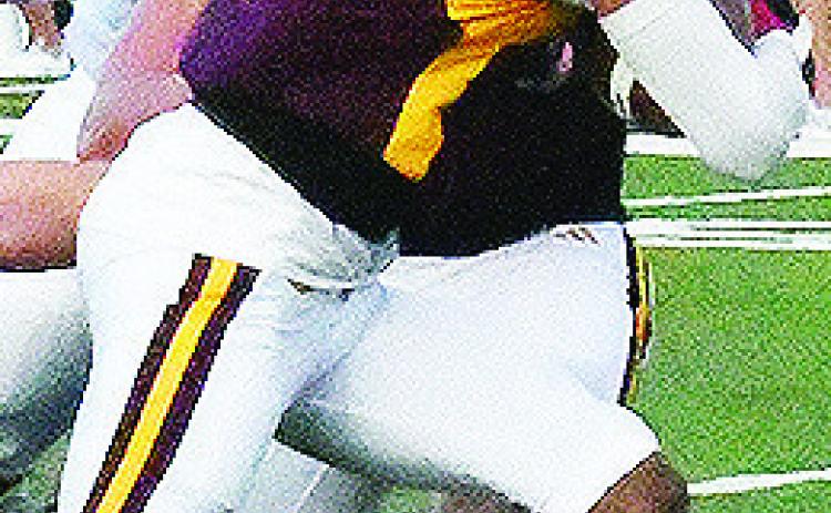 Clinton’s Derren Hester busts through the line of scrimmage with the ball for a gain during the Red Tornadoes’ game against Heritage Hall Friday. CDN | John Kinsey