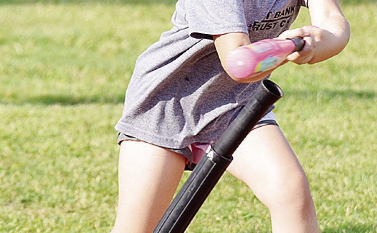 Valarie Tobias swings mightly at the ball during a Noon Lion’s Club T-Ball game at Schumacher Fields at Acme Brick Park. CDN | Sam Goodwyn