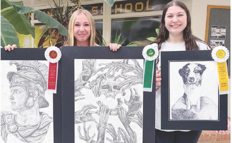 Clinton High School art students Madison Walker, left, and Brooks Aston show off their entries for the Elk City Fall Festival. Walker placed second and fourth place in the Graphics 2 Division, and Aston placed third in the Graphics 1 Division. CDN | Courtesy photo