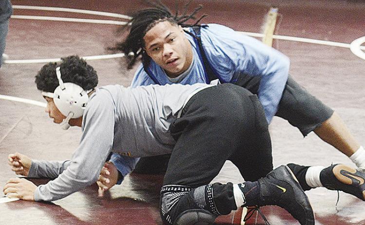 Clinton’s Malachi Lorne, top, attempts to wrap himself around Tyson Brookter during wrestling practice. CDN | Sam Goodwyn