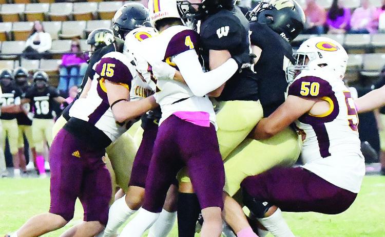 Clinton’s No. 15 Dyson Moss, No. 4 Zaryk Baker and No. 50 Alex Amaya take down the Woodward ball carrier during the Red Tornadoes’ win over the Boomers. CDN | John Kinsey