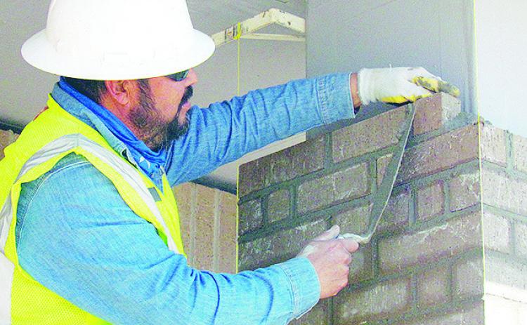 Carlos Quilantan places bricks on a column Wednesday at the Troop H Oklahoma Highway Patrol Headquarters construction site. CDN | Christian Jacobsen