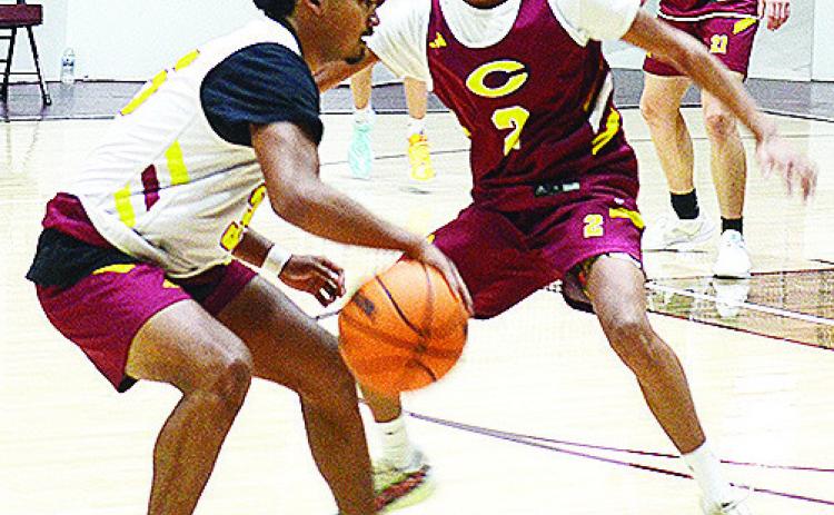 Clinton’s Adam Flores, left, dribbles around teammate Ronnie Redshin during a recent practice in the Tornado Dome. CDN |Sam Goodwyn