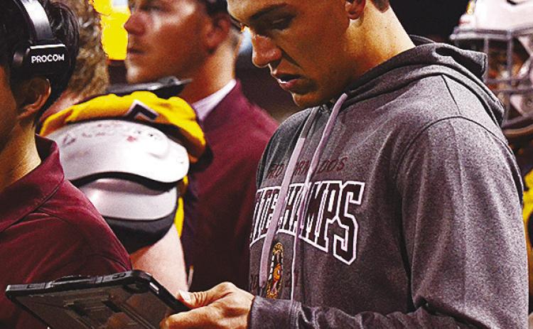Former Clinton Red Tornado football player Caden Powell reads info off of a tablet Friday during Clinton’s homecoming game against Elgin. CDN | Micah Ashcraft