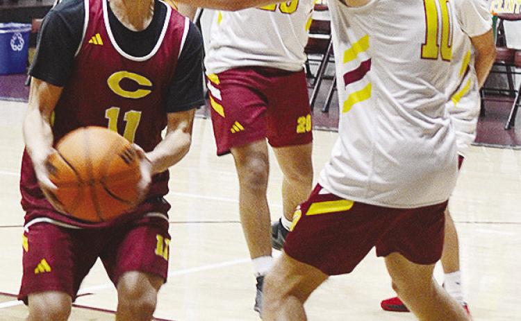 Clinton’s AJ Reynolds, left, fights through teammate Parker Adams on his way to the basket during practice in the Tornado Dome. CDN | Sam Goodwyn