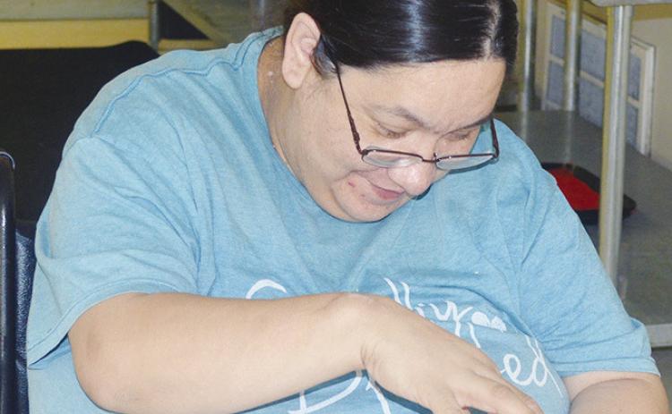 Martha Zamora fights to get the cheese spread on her cracker as it kept falling off at the River Valley Therapy Center. CDN | Christian Jacobsen
