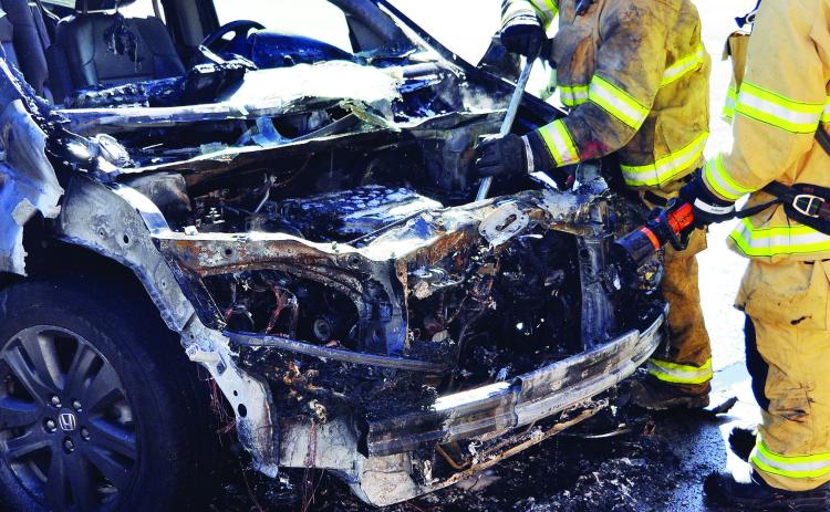 Clinton Firefighters Bobby Winans and Alex Tyler make sure this torched van does not reignite Monday afternoon in the 1600 block of Dunn Avenue. CDN | Staff Photo