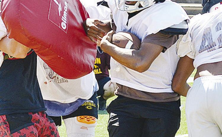 Clinton’s Derren Hester fights through the line of scrimmage carrying the ball during practice in the Tornado Bowl. CDN | Sam Goodwyn