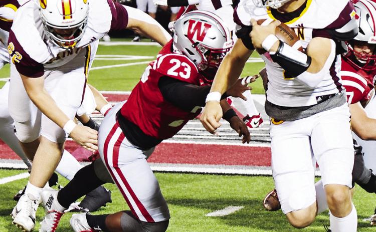 Clinton’s No. 62 Layne Spitz, left, blocks Weatherford’s Daniel Cornell as Easten Powell carries the ball during the “Custer County Conflict” Friday in Weatherford. CDN | John Kinsey