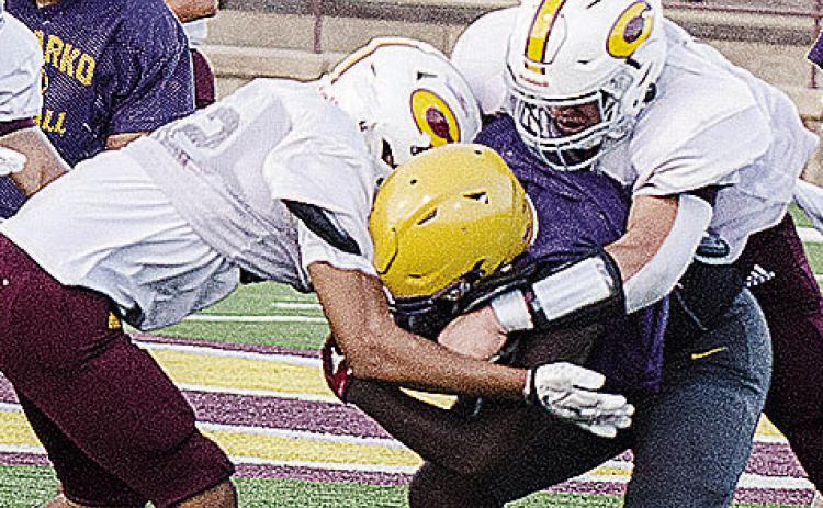 Clinton’s CJ Begay, left, and Easten Powell come together to tackle the Anadarko ball carrier during the Red Tornadoes’ scrimmage Friday at the Tornado Bowl. CDN | Sam Goodwyn