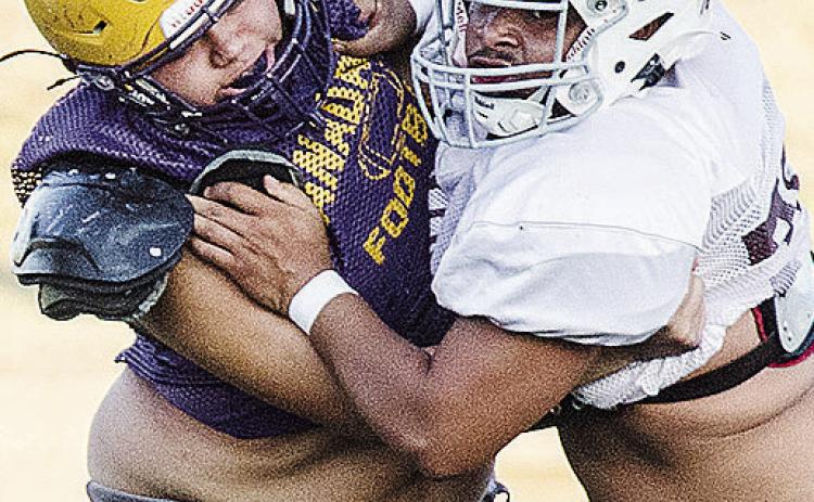 Clinton’s Roderick Barker, right, blocks an Anadarko defender during the Red Tornadoes’ scrimmage in the Tornado Bowl. CDN | Sam Goodwyn