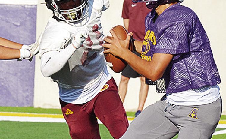 Clinton’s Gavin Evans, left, beats the block around the edge as he hustles toward the quarterback during the Red Tornadoes’ scrimmage Friday in Anadarko. CDN | Sam Goodwyn