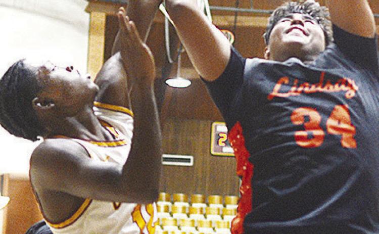 Clinton’s Atticus Thompson tries to block a shot during the Reds’ homeopener against the Lindsay Leopards in the Tornado Dome. CDN | Sam Goodwyn