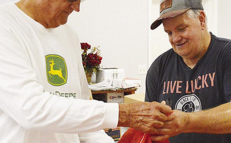 Mission House board member Sam Shelton, left, and Mark Rice check on potatoes delivered to the Mission House food pantry Tuesday morning. CDN | Micah Ashcraft