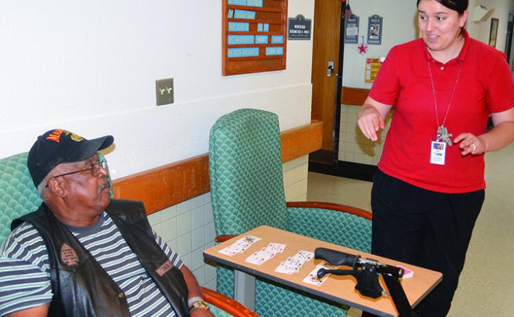Naval veteran Jack Giles, left, is shown a new card trick by Amelia Hardaway Wednesday at the Oklahoma Veterans Center, Clinton Branch. CDN | Christian Jacobsen